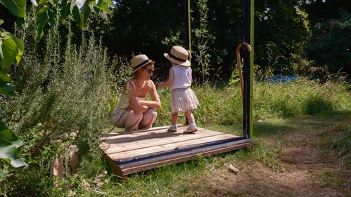 A mum and daughter try on straw hats as part of the summer of play at Paycocke's House, Essex